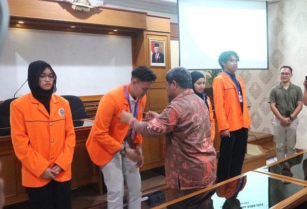 Wakil Rektor UAD, Prof Sunardi mengalungkan kartu identitas sebagai tanda pelepasan mahasiswa peraih beasiswa IISMA dan AIMS di Kampus I Yogyakarta, Rabu (21/8/2024). (foto : heri purwata)