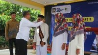 Rektor UII mengalungkan kartu identitas siswa sebagai tanda peluncuran Sekolah Lansia di Kotagede, Yogyakarta, Rabu (26/2/2025). (foto : heri purwata)